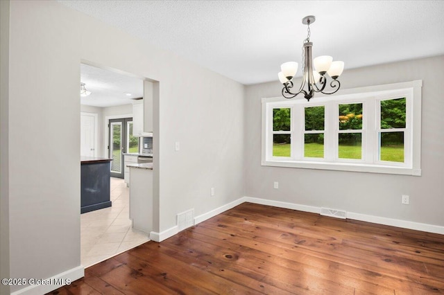 61 Lemaire Way, Argyle, NY 12809 - unfurnished dining area featuring a chandelier and light wood-type flooring