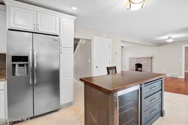 61 Lemaire Way, Argyle, NY 12809 - kitchen featuring stainless steel fridge, beverage cooler, open floor plan, white cabinets, and dark countertops