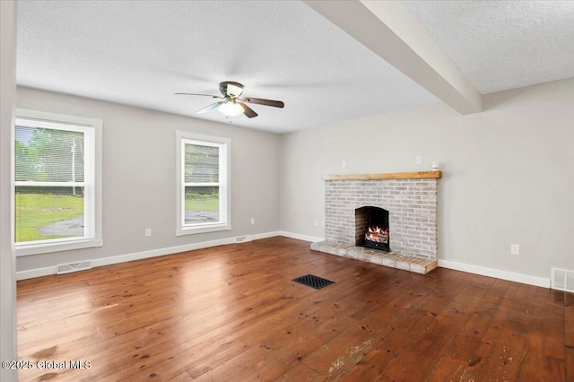 61 Lemaire Way, Argyle, NY 12809 - unfurnished living room with ceiling fan, wood-type flooring, a brick fireplace, and a textured ceiling