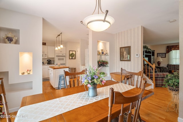 1401 Balltown Rd, Niskayuna, NY 12309 - dining area featuring light wood-type flooring, stairs, wallpapered walls, and baseboards