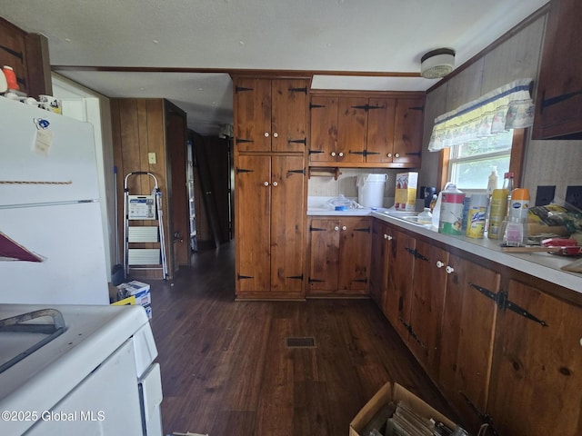 1056 Carlisle Rd, Root, NY 13317 - kitchen with dark wood-style floors, freestanding refrigerator, brown cabinets, and light countertops
