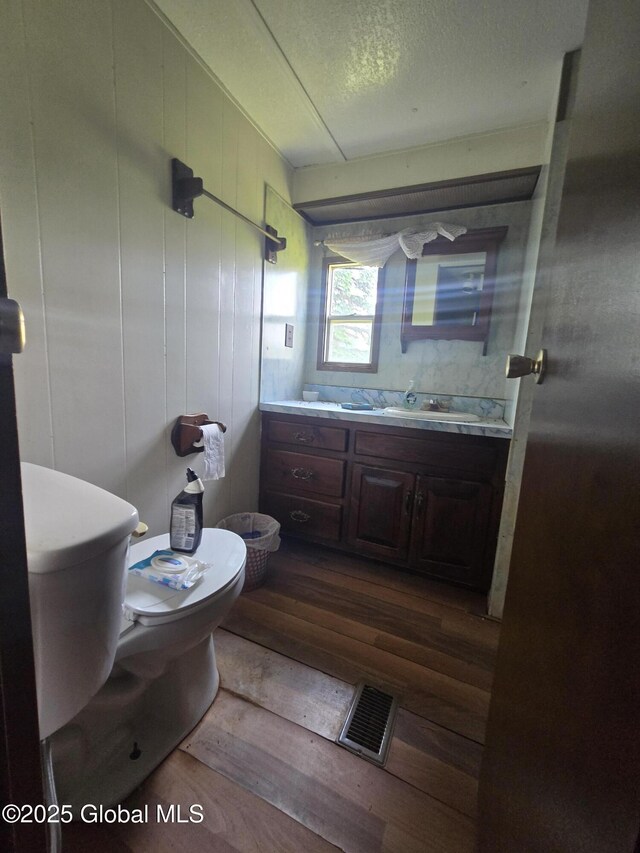 1056 Carlisle Rd, Root, NY 13317 - half bathroom featuring wood finished floors, vanity, and toilet