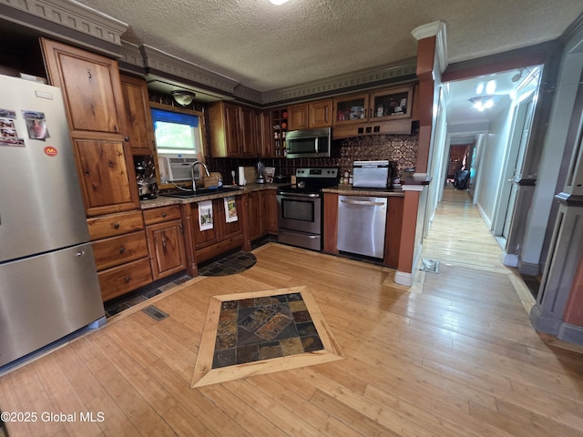 3841 State Highway 30, Mayfield, NY 12010 - kitchen with appliances with stainless steel finishes, a textured ceiling, light wood finished floors, glass insert cabinets, and a sink