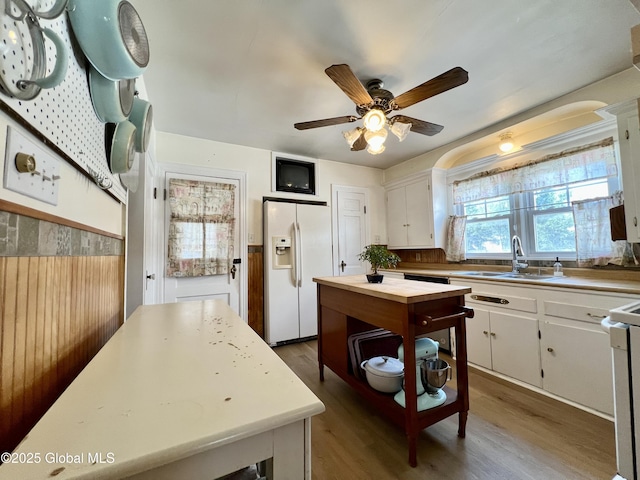 2803 Wellington Ave, Rotterdam, NY 12306 - kitchen with white refrigerator with ice dispenser, a sink, ceiling fan, wood finished floors, and white cabinets