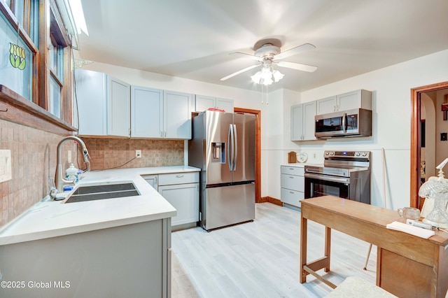 55 Crescent Ave, Amsterdam, NY 12010 - kitchen with stainless steel appliances, a sink, light countertops, a ceiling fan, and tasteful backsplash