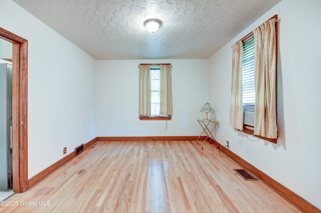 55 Crescent Ave, Amsterdam, NY 12010 - empty room featuring wood finished floors, healthy amount of natural light, a textured ceiling, and baseboards