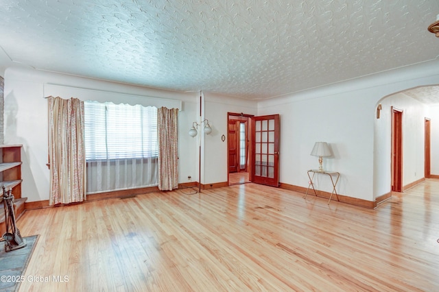55 Crescent Ave, Amsterdam, NY 12010 - unfurnished living room with wood finished floors, arched walkways, and baseboards