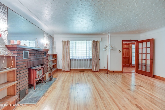 55 Crescent Ave, Amsterdam, NY 12010 - living area with hardwood / wood-style floors, a wood stove, baseboards, and a textured ceiling