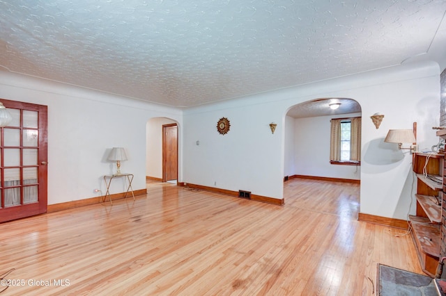 55 Crescent Ave, Amsterdam, NY 12010 - empty room with arched walkways, wood finished floors, a textured ceiling, and baseboards