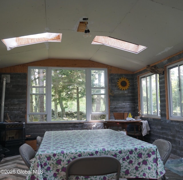 127 Fern Ln, Jefferson, NY 12093 - dining space with a skylight, vaulted ceiling, a wood stove, plenty of natural light, and wooden walls