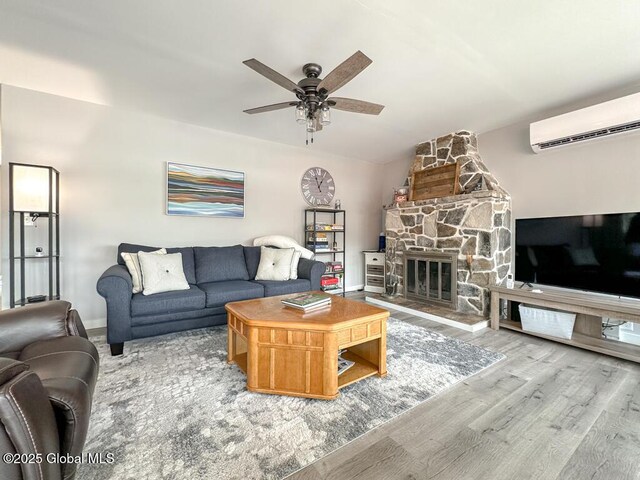 3602 Echo Bay Ln, Fort Ann, NY 12844 - living area with a wall unit AC, wood finished floors, ceiling fan, a fireplace, and vaulted ceiling