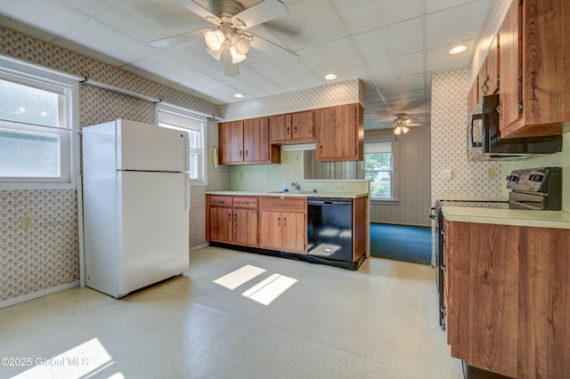 510 S William St, Johnstown, NY 12095 - kitchen featuring freestanding refrigerator, range with electric stovetop, black dishwasher, a ceiling fan, and wallpapered walls