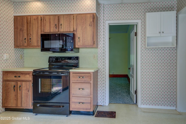 510 S William St, Johnstown, NY 12095 - kitchen featuring black appliances, wallpapered walls, light countertops, brown cabinets, and light floors