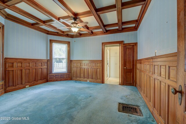 510 S William St, Johnstown, NY 12095 - carpeted spare room featuring a wainscoted wall, beamed ceiling, coffered ceiling, and a ceiling fan