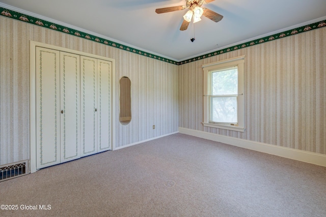 510 S William St, Johnstown, NY 12095 - unfurnished bedroom with carpet flooring, crown molding, a closet, ceiling fan, and wallpapered walls