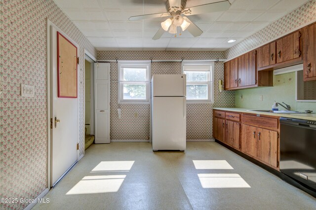 510 S William St, Johnstown, NY 12095 - kitchen with freestanding refrigerator, black dishwasher, wallpapered walls, light countertops, and brown cabinets