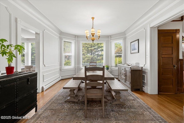 4 Van Dyke Ave, Amsterdam, NY 12010 - dining room with a decorative wall, a chandelier, wood finished floors, healthy amount of natural light, and a baseboard radiator