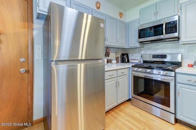 8 Birchtree Ln, Milton, NY 12020 - kitchen featuring stainless steel appliances, light countertops, light wood-style flooring, and tasteful backsplash