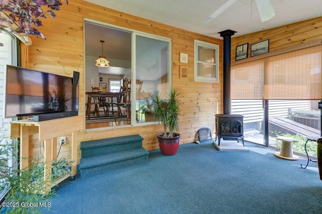 8 Birchtree Ln, Milton, NY 12020 - living room with a wood stove, wood walls, carpet flooring, and ceiling fan