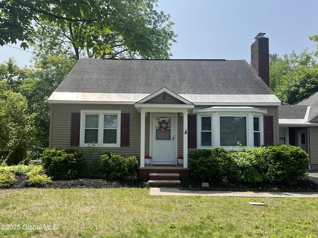 6 Pine Rd, Moreau, NY 12803 - view of front of house featuring a front lawn, a chimney, and roof with shingles