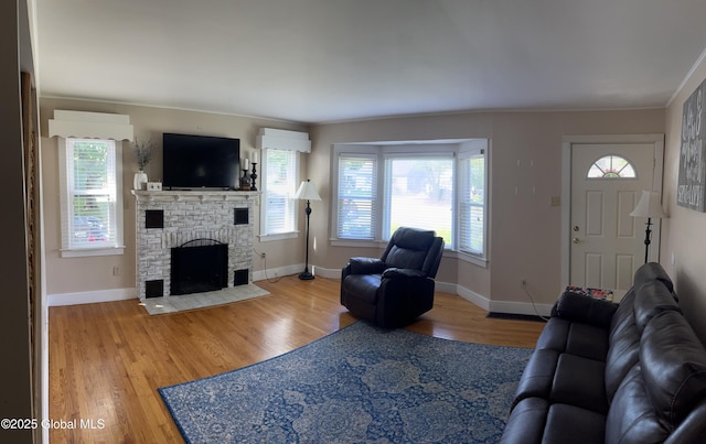 6 Pine Rd, Moreau, NY 12803 - living area with plenty of natural light, wood finished floors, a brick fireplace, and baseboards