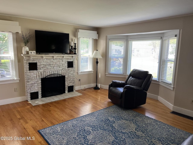 6 Pine Rd, Moreau, NY 12803 - living room featuring a fireplace, wood finished floors, plenty of natural light, baseboards, and ornamental molding