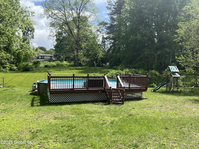 6 Pine Rd, Moreau, NY 12803 - outdoor pool with a deck, a lawn, a playground, and view of scattered trees