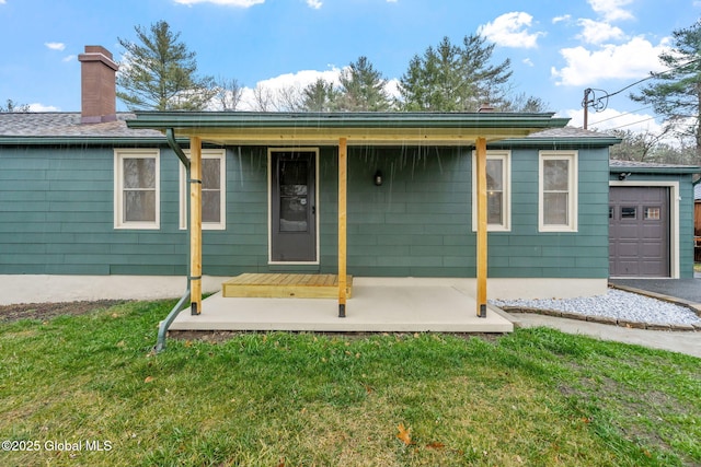 16 Smith Ln, East Greenbush, NY 12144 - rear view of house with a yard, a chimney, a garage, and covered porch
