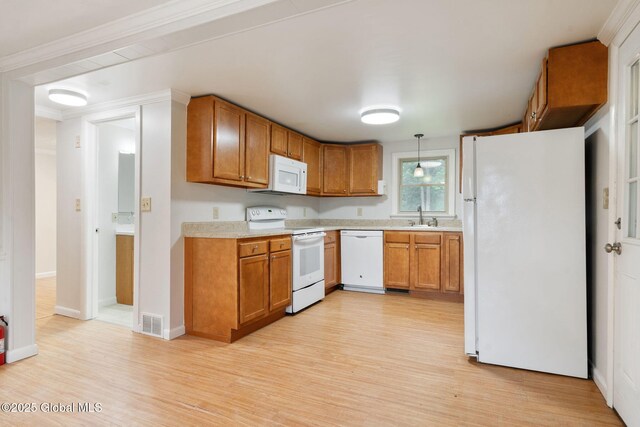 16 Smith Ln, East Greenbush, NY 12144 - kitchen with white appliances, light countertops, light wood-type flooring, brown cabinets, and hanging light fixtures