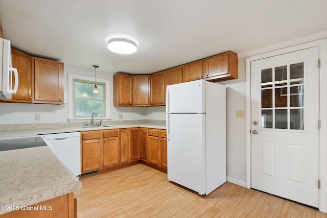 16 Smith Ln, East Greenbush, NY 12144 - kitchen with white appliances, a sink, light wood-style flooring, brown cabinetry, and light countertops