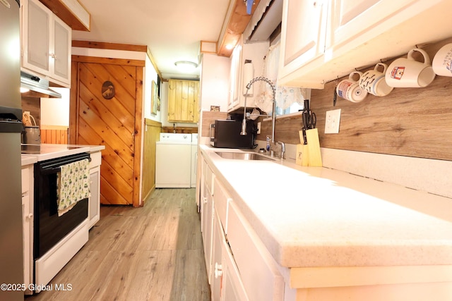 68 Elks Glade Rd, Chester, NY 12817 - kitchen featuring electric range oven, separate washer and dryer, under cabinet range hood, light wood-type flooring, and light countertops