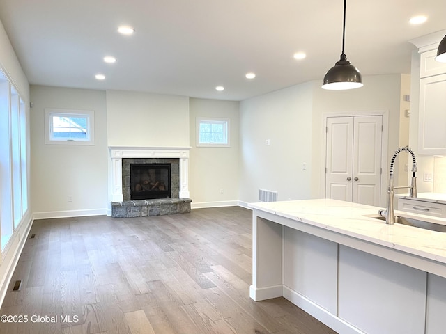 1 Jennifer Ln, Milton, NY 12020 - kitchen featuring a sink, light stone counters, baseboards, white cabinets, and wood finished floors