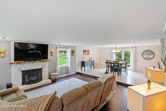 1396 Barton Hill Rd, Wright, NY 12053 - living room with healthy amount of natural light, wood finished floors, a chandelier, and a brick fireplace