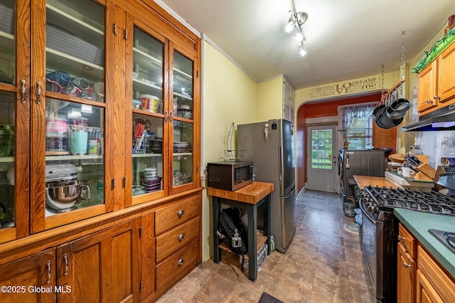 58 N Allen St, Albany, NY 12203 - kitchen featuring stainless steel appliances, arched walkways, brown cabinetry, under cabinet range hood, and glass insert cabinets