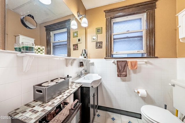 58 N Allen St, Albany, NY 12203 - bathroom featuring tile walls, plenty of natural light, toilet, vanity, and a wainscoted wall