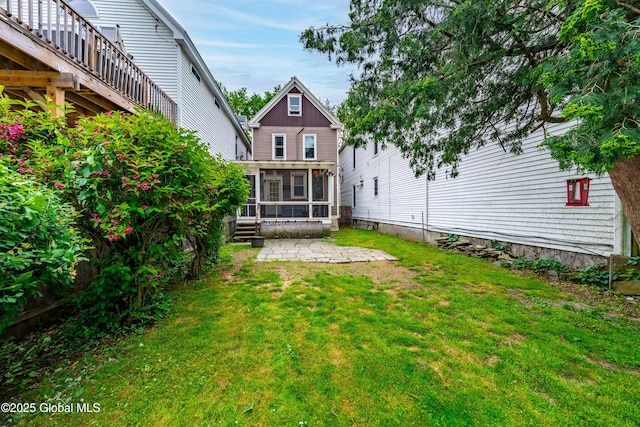58 N Allen St, Albany, NY 12203 - rear view of property featuring a sunroom, a patio area, and a lawn