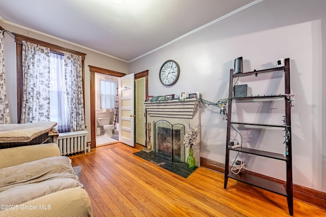 58 N Allen St, Albany, NY 12203 - living room featuring radiator, a fireplace with flush hearth, hardwood / wood-style flooring, crown molding, and baseboards