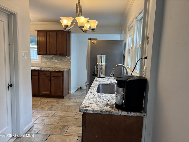 1922 Regent St, Niskayuna, NY 12309 - kitchen with freestanding refrigerator, a chandelier, tasteful backsplash, light stone counters, and crown molding