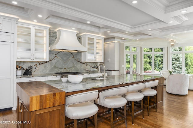 1 Stoneridge Dr, Colonie, NY 12211 - kitchen with custom exhaust hood, dark stone countertops, tasteful backsplash, crown molding, and wood finished floors