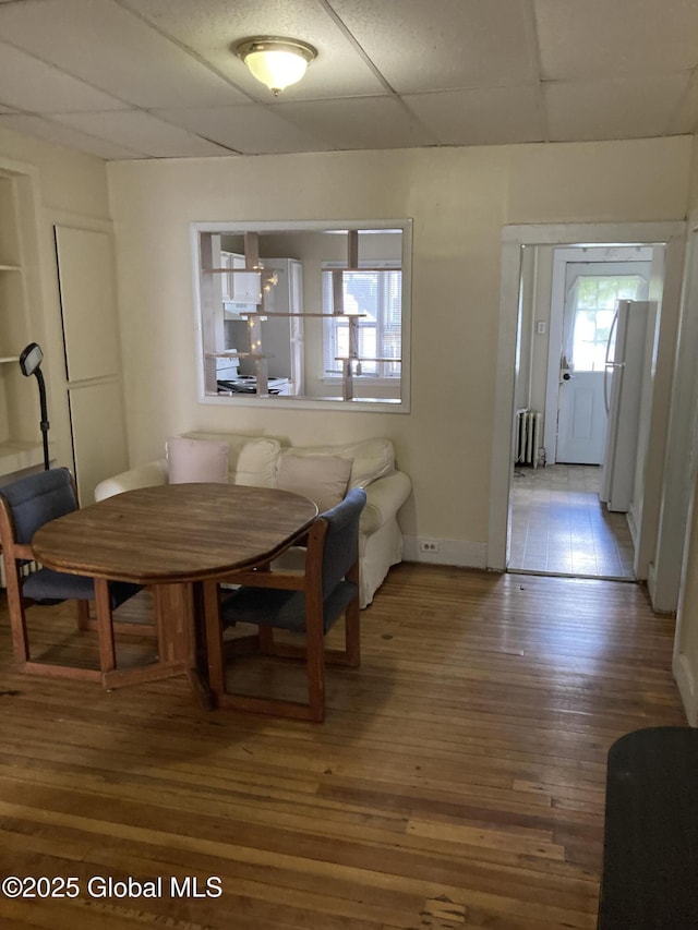 45 14th St, Troy, NY 12180 - dining area featuring radiator heating unit, hardwood / wood-style flooring, a drop ceiling, and baseboards