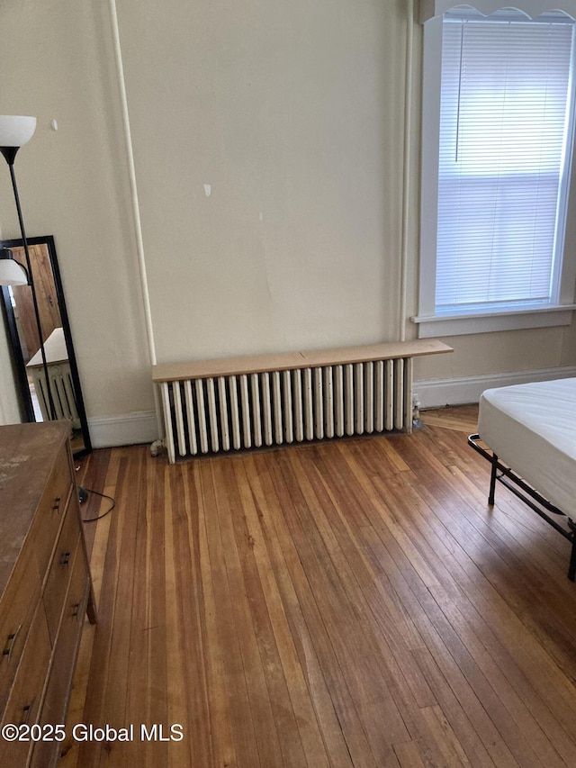 45 14th St, Troy, NY 12180 - unfurnished bedroom featuring radiator heating unit, hardwood / wood-style floors, and baseboards