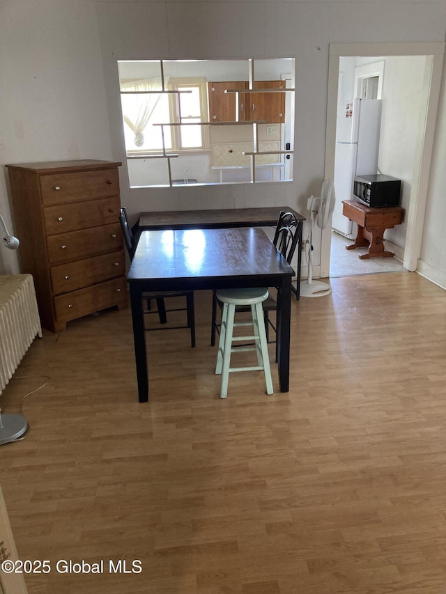 45 14th St, Troy, NY 12180 - dining area with light wood-style floors and radiator heating unit