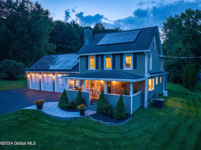 363 Goodman Rd, Fort Ann, NY 12827 - view of front facade featuring covered porch, a chimney, roof mounted solar panels, a garage, and a shingled roof