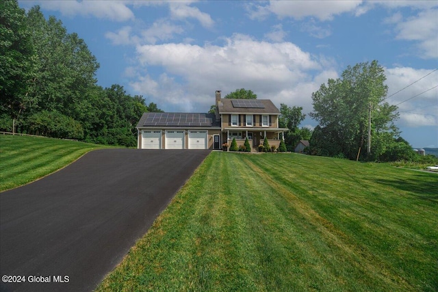 363 Goodman Rd, Fort Ann, NY 12827 - view of front of home with a garage, driveway, a front lawn, solar panels, and a chimney