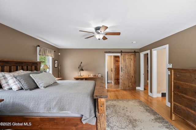 363 Goodman Rd, Fort Ann, NY 12827 - bedroom featuring wood finished floors, a barn door, baseboards, and ceiling fan