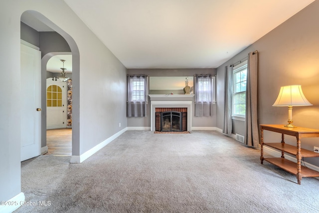 1298 Mcclellan St, Schenectady, NY 12309 - unfurnished living room featuring carpet, arched walkways, and a brick fireplace