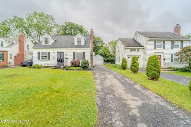 1298 Mcclellan St, Schenectady, NY 12309 - view of front of house featuring a front yard, an outdoor structure, a garage, and a chimney