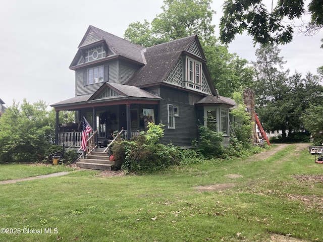 48 Spring St, Port Henry, NY 12974 - victorian home featuring a porch, a front yard, and a shingled roof