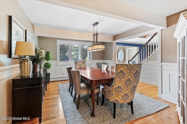 17 Cypress Pt, Clifton Park, NY 12065 - dining room featuring wainscoting, a decorative wall, light wood finished floors, stairs, and a baseboard heating unit