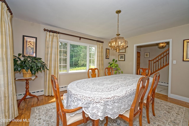 805 Karenwald Ln, Schenectady, NY 12309 - dining area with a chandelier, a baseboard heating unit, light wood-type flooring, and stairs